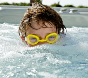 Boy in goggles half way under water